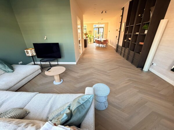 Woonkamer met een Therdex Premier 6584 PVC vloer in Weense punt, doorlopend naar de keuken en de tuindeuren